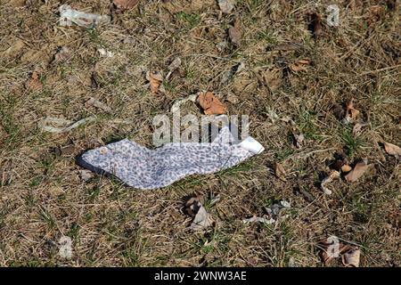 Liter (disposable face mask) laying in grass along a roadside Stock Photo