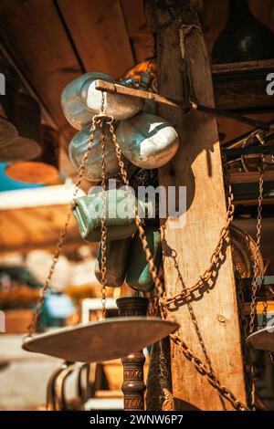 Vintage metal and plastic canteens, copper plates, pots and old rusty balance scales in a shop at antique bazaar Stock Photo