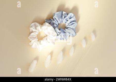 two silk scrunchies on light white. Flat lay Hairdressing tools and accessories. Elastic Hair Bands, Bobble Sports from above Stock Photo