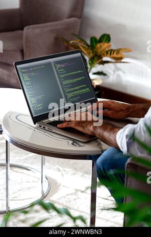 Developer programmer writing html javascript code in a laptop. Vertical format. Stock Photo