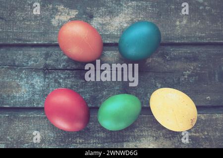 Multi-colored eggs painted with gouache and onion peel close up on wooden background. Five boiled eggs. Postcard poster for Easter. Easter holiday Stock Photo