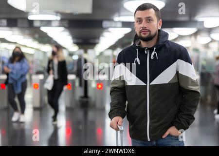 Young traveler going with suitcase on subway station Stock Photo