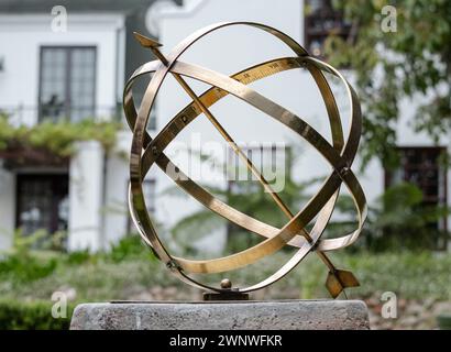 Large scale garden armillary sundial sphere with arrow and roman numerals. Hotel backyard Stock Photo