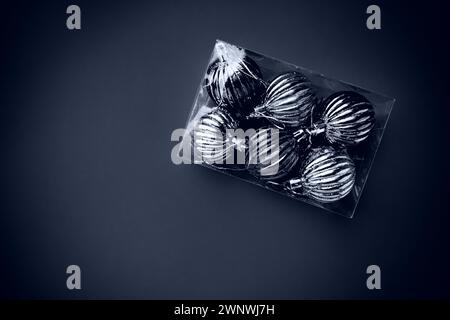 Box with Christmas tree decorations. Gift or purchase. Happy New Year and Merry Christmas. Shiny balls in a package. Black and white monochrome photo Stock Photo