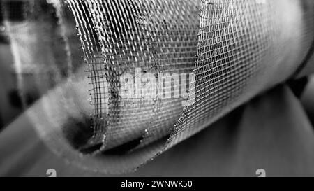 Metal mesh. Rolled mesh in gray. Heavy duty steel or aluminum mesh with ragged edges. Stock Photo