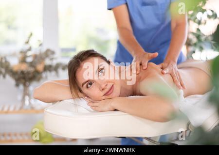 Young woman enjoying massage from professional female masseur Stock Photo