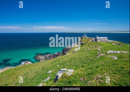 View of the coastal path, around the headland in St. Ives, Cornwall, England. It is a summer's day and the sea is a clear blue and aqua colour. Stock Photo
