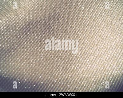 A close-up fabric with lurex. The texture of the fabric with grooves and lines. It's a uneven surface. Dark vignettes around the edges. Stock Photo