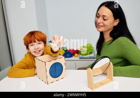 Mental health for kids. Professional kids psychologist working with cute male child in office during play therapy session Stock Photo