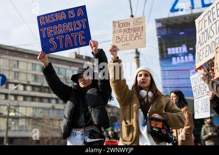 Young Ukrainian females hold banners 'russia is a terrorist state' and 'Silence and Captivity Kills' on a public rally in Ukraine. Kyiv - 3 March, 2024 Stock Photo