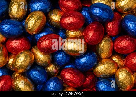 Chocolate easter eggs in colorful tinfoil close up full frame as background Stock Photo