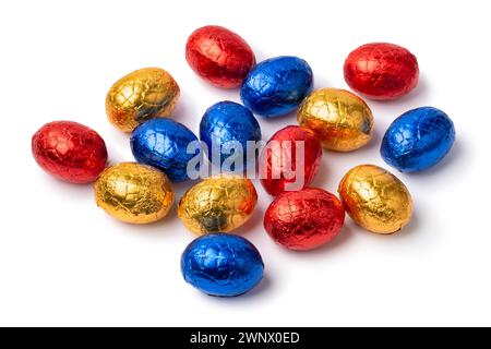 Heap of chocolate easter eggs in colorful tinfoil close up isolated on white background Stock Photo