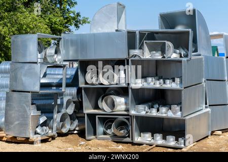 Various sheet metal air ducts in stock for installation in a building under construction. Ventilation system for large buildings. Ventilation pipes ma Stock Photo