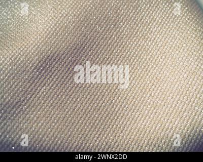 A close-up fabric with lurex. The texture of the fabric with grooves and lines. It's a uneven surface. Dark vignettes around the edges. Stock Photo