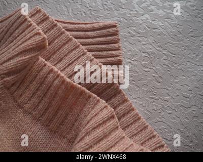 Knitted knitwear. Knitted warm winter sweater or close-up jumper. Wool or polyester threads. Clothing production. The texture of the knitted thing Stock Photo