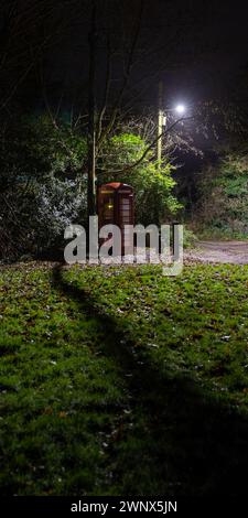 A telephone box re-purposed to house a defibrillator at night, Kent. Stock Photo