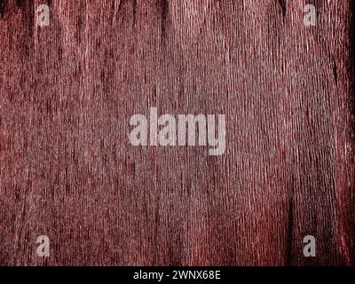 Corrugated paper in red. Uneven surface. Abstract background. Wavy edges of the paper sheet. Lighting gradient Stock Photo