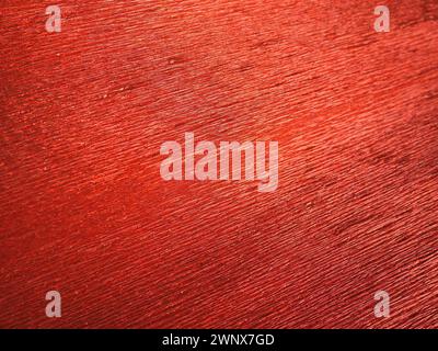 Corrugated paper in red. Uneven surface. Abstract background. Wavy edges of the paper sheet. Lighting gradient Stock Photo