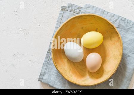 Overhead shot of colourful Easter eggs on linen tablecloth with copy space Stock Photo