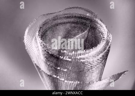 Metal mesh. Rolled mesh in gray. Heavy duty steel or aluminum mesh with ragged edges. Stock Photo