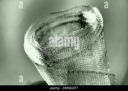 Metal mesh. Rolled mesh in gray. Heavy duty steel or aluminum mesh with ragged edges. Stock Photo