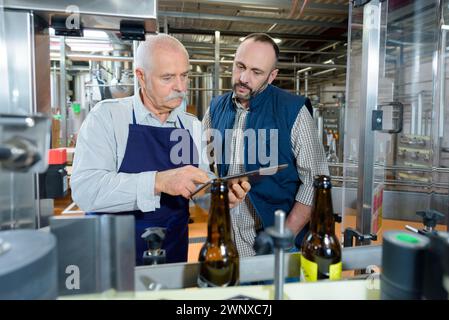 coworkers discussing over digital tablet in brewery Stock Photo