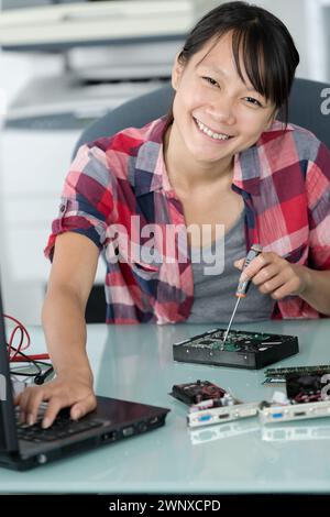 female asian computer technician using multimeter Stock Photo
