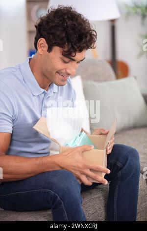 male opens box smiling and surprised Stock Photo