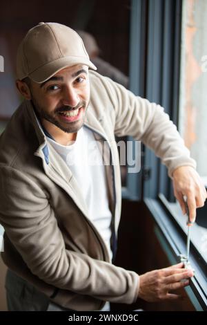 man installing roller shutter on window Stock Photo