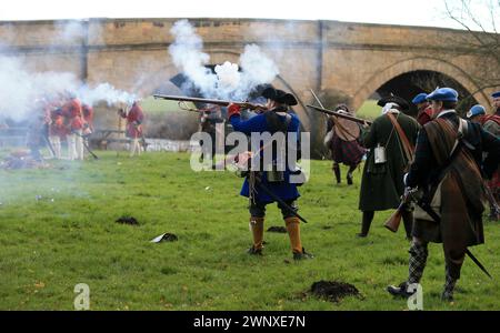 07/12/13   Dressed in period uniforms and using replica weapons, 'soldiers' re-enact the Jacobite uprising of 1745 at Swarkestone Bridge Derbyshire. T Stock Photo