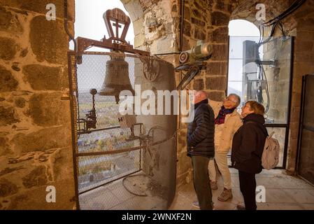 Tourists looking at the bells of the bell tower of Santa Maria of Puigcerdà (Cerdanya, Girona, Catalonia, Spain, Pyrenees) Stock Photo