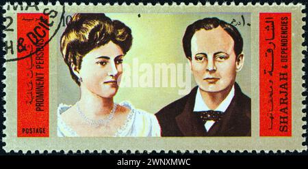 SHARJAH - CIRCA 1972: A stamp printed in United Arab Emirates shows Winston Churchill and Queen Alexandra of England Stock Photo