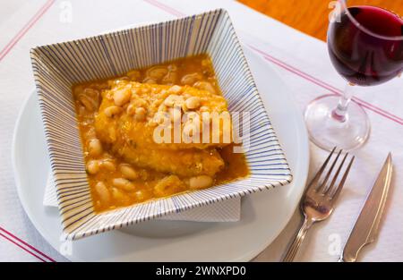Large piece of lean cod fillet stewed in bean gravy Stock Photo - Alamy