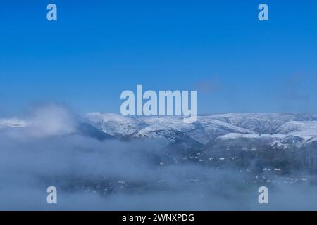 An inversion mist in the Stretton Valley with snow on the Long Mynd, Church Stretton, Shropshire Stock Photo