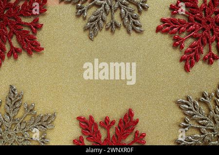 Six large silver and red flat ornate snowflakes are laid out on velvety gold paper. Free space for text. New Year or Christmas background for Stock Photo