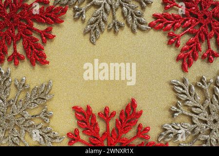 Six large silver and red flat ornate snowflakes are laid out on velvety gold paper. Free space for text. New Year or Christmas background for Stock Photo