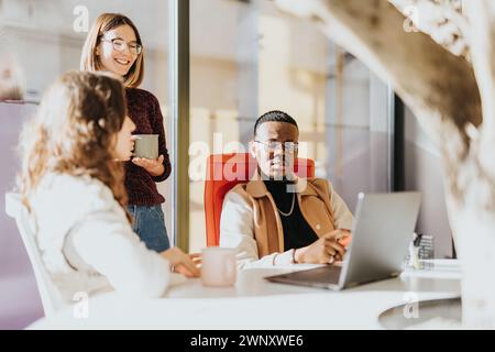 Business colleagues are collaborating, discussing project details, and sharing ideas for business growth and profitability. Stock Photo