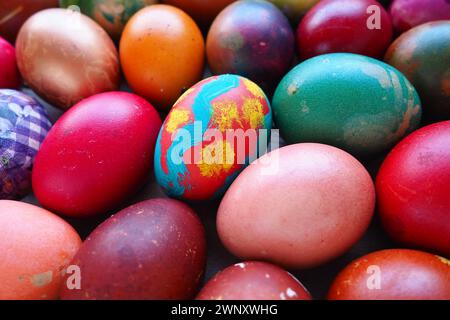 Easter colorful eggs close up. Many colorful holiday eggs are stacked close to each other. Boiled chicken eggs with floral and fantasy pattern. Bright Stock Photo