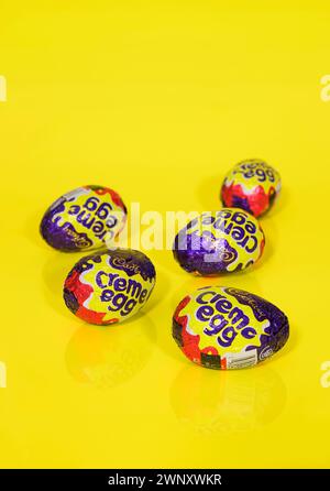 Five Cadbury Creme Eggs on Yellow Background, Easter Eggs Stock Photo