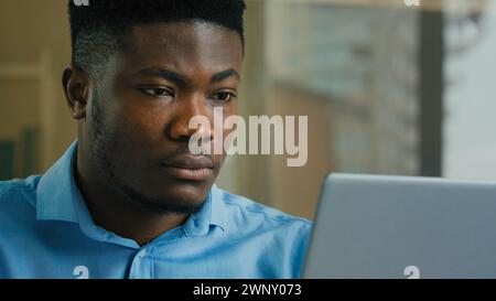 African American business man employee professional manager working on laptop computer from home office male ethnic executive studying browsing web Stock Photo