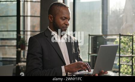 African American multiethnic businessman employee professional manager using laptop typing email on keyboard focused mature senior man search digital Stock Photo