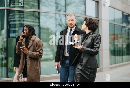 Diverse people engaging in a business discussion outside modern office building. Stock Photo