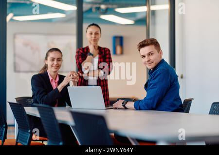 A team of successful programmers sits in a startup office, strategizing new business projects and solving existing challenges, showcasing innovation Stock Photo