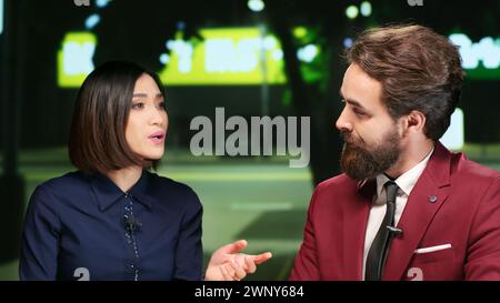 Reporters team on night talk show, presenting daily events and international issues on live program. Professional hosts doing newscast segment for entertainment, talking about latest media scandals. Stock Photo