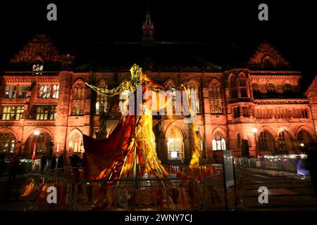 Rochdale, UK.  4th March, 2024.  Rochdale Festival Of Ideas opens with a light show at the iconic Town Hall marking the buildings re- opening.  Visitors are been encourages to visit the Victorian Gothic Grade 1 listed building.  The Living Dress, an outdoor installation, naturally dyed and handmade with the help of local communities, is worn by a 5m tall sculpture in front of the Town Hall. Rochdale, UK. Credit: Barbara Cook/Alamy Live News Stock Photo