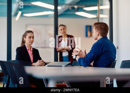 A team of successful programmers sits in a startup office, strategizing new business projects and solving existing challenges, showcasing innovation Stock Photo