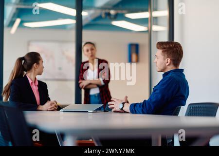 A team of successful programmers sits in a startup office, strategizing new business projects and solving existing challenges, showcasing innovation Stock Photo