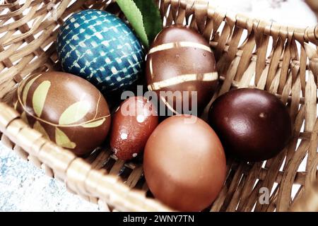 Easter boiled eggs of different colors dyed with onion peel and paint in wicker basket. Vegetable patterns on the shell. Traditional festive coloring Stock Photo