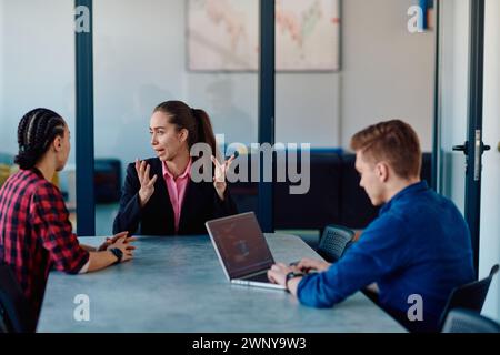 A team of successful programmers sits in a startup office, strategizing new business projects and solving existing challenges, showcasing innovation Stock Photo