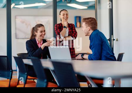 A team of successful programmers sits in a startup office, strategizing new business projects and solving existing challenges, showcasing innovation Stock Photo